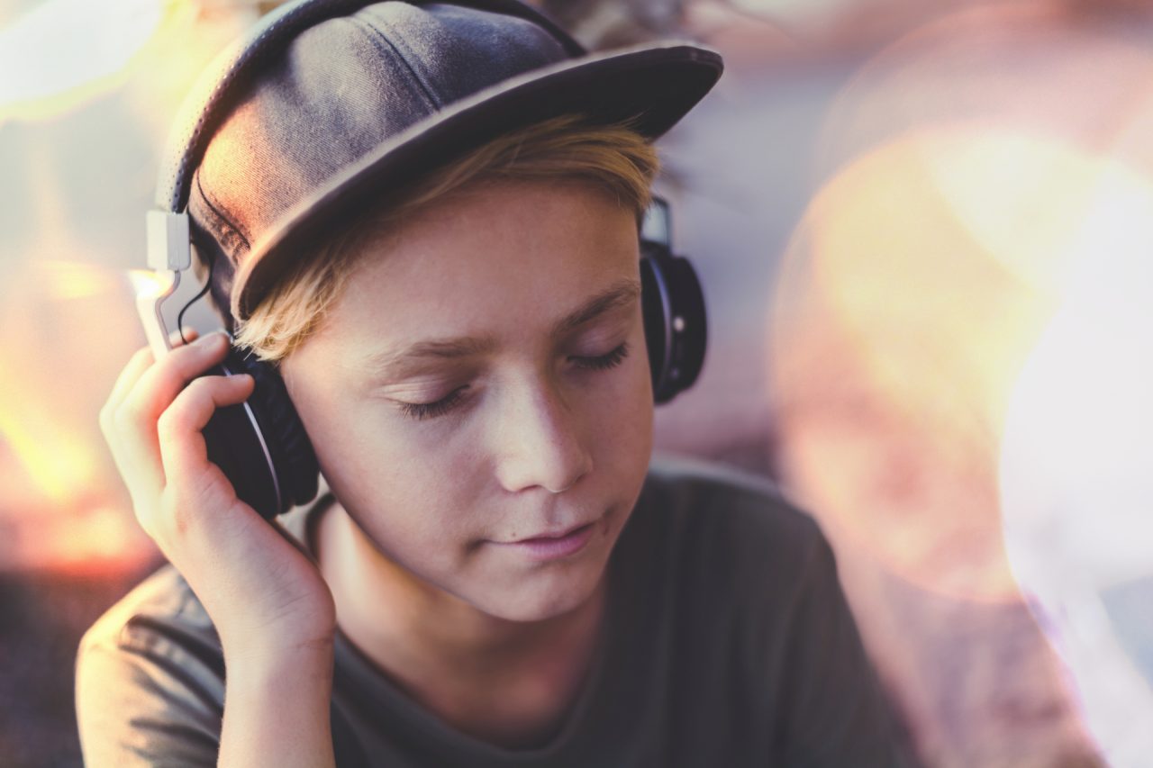 teen-enjoying-sound-with-headphones-beautiful-boy-with-earphones-hat-relax-listening-music